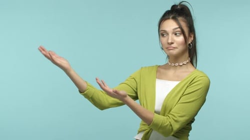 Schönes europäisches Mädchen in stilvoller Kleidung präsentiert Ihnen ein Werbebanner, das mit den Händen nach links zeigt und