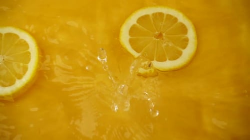 Lemons Splashing into Orange Juice