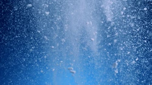 White Powder Falling Against Blue Abstract Background