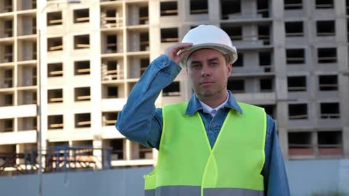 Construction Worker Smiling Wearing a Hardhat on Building Site