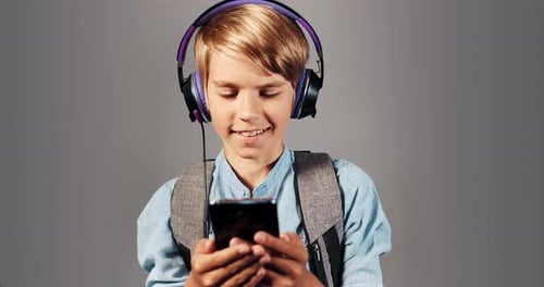 Boy with Headphones Using Mobile Phone