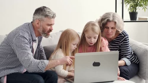 Grandparents and Granddaughters Using Laptop Together at Home