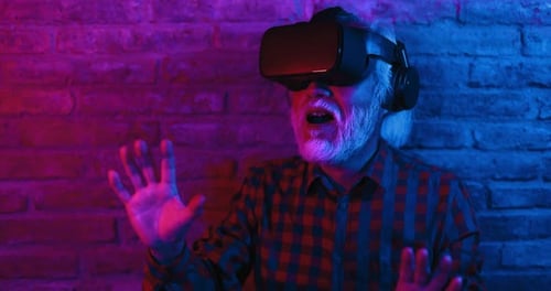 Senior Man Using VR Headset Indoors at Night