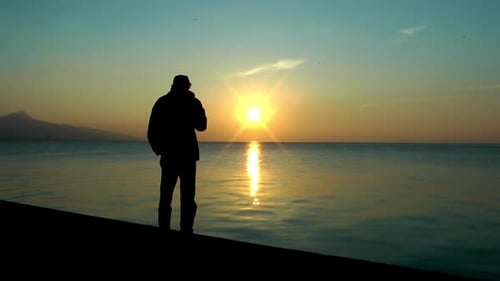 Alone Man raucht Zigaretten in der Nähe des Meeres und schaut aufs Meer
