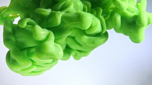 Green Color Paint Drops in Water Against White Background.