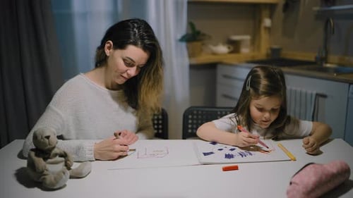 Woman and Child Drawing Together in Kitchen at Home