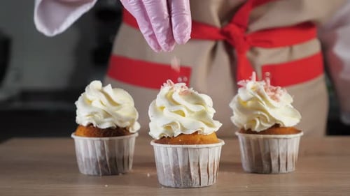 Cupcakes Decorated with Sprinkles by Baker in Kitchen