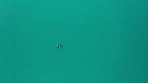 Drone flight over fishing boats in turquoise green sea