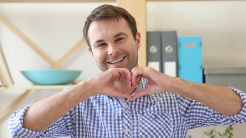 Smiling Man Making Heart Shape with Hands