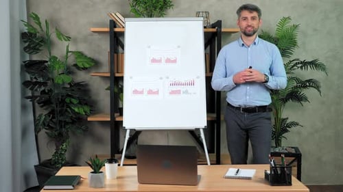 Man Presents Graphs in Office Workplace