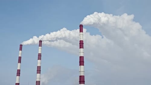 White Smoke From the Chimneys of a Thermal Power Plant Against the Blue Sky Slow Motion