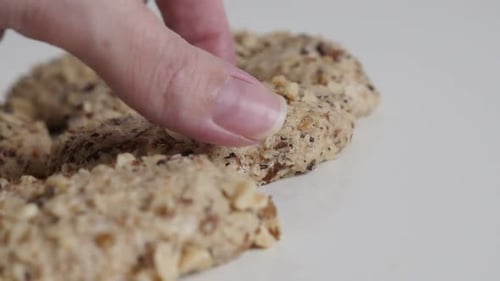 Hand Picking Up Homemade Nut Cookie