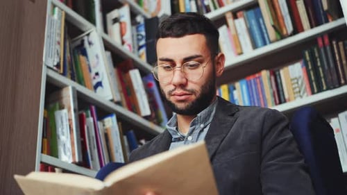 Intelligent Man Reading Book in Book Shop