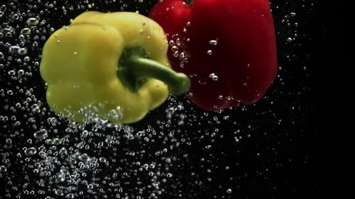 Vibrant Bell Peppers Falling Into Clear Water