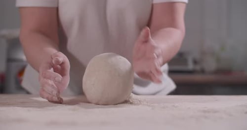 Weibliche Hände kneten und werfen Teig auf die Küche