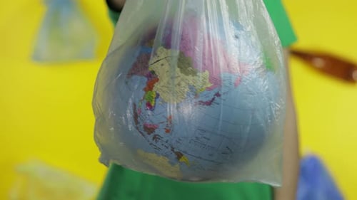 Mujer irreconocible con globo terráqueo en paquete de plástico. Salva la ecología. Contaminación natural plástica