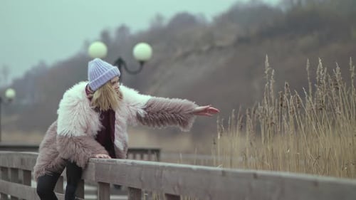 Stylish Woman in Plush Coat Posing on Pier