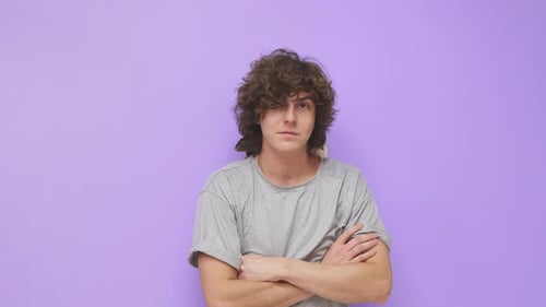 Ein junger Mann mit lockigem Haar lächelt in die Kamera auf einem isolierten Hintergrund, auf dem eine Hausratte sitzt