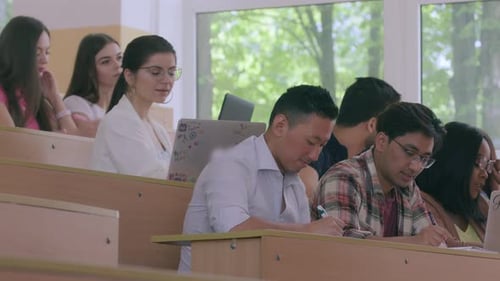 Side View of Racially Mixed Students Listening To Lecture