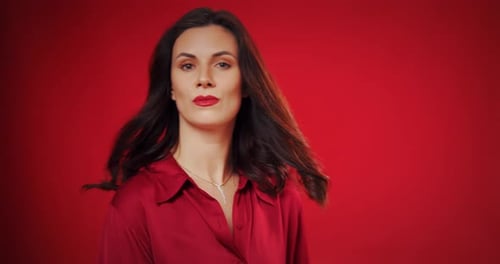 Beautiful Woman Poses in Studio on Colored Background