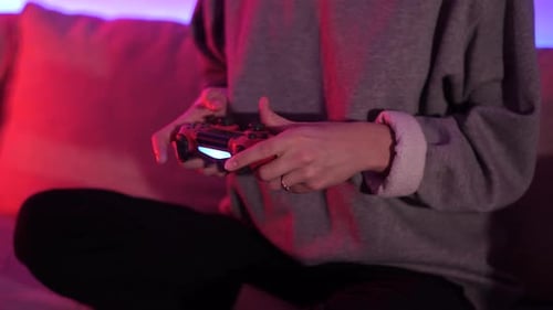 A girl plays computer games. Game console. Game controller. Gamepad in the hands. Gaming.