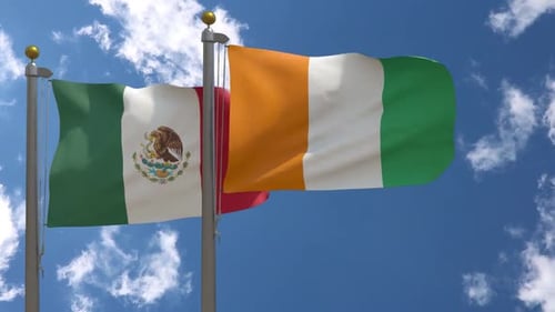 Flags of Mexico and Ivory Coast Waving in Sunny Blue Sky