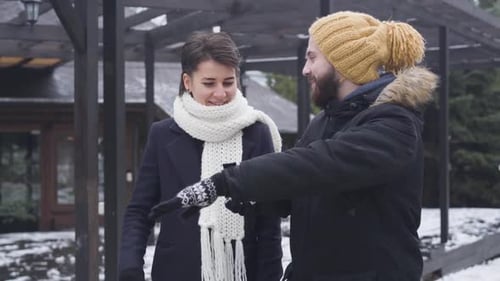 Portrait of Caucasian Man and Woman Walking Along the Street in Winter Outfit. Cheerful Boyfriend