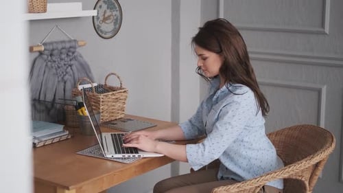 Portrait of an Attractive Young Woman Working in a Home Studio. Freelancer Working on a Laptop