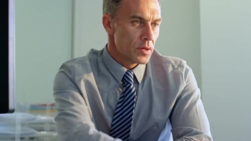 Geschäftsmann arbeitet am Schreibtisch in einem modernen Büro 4k