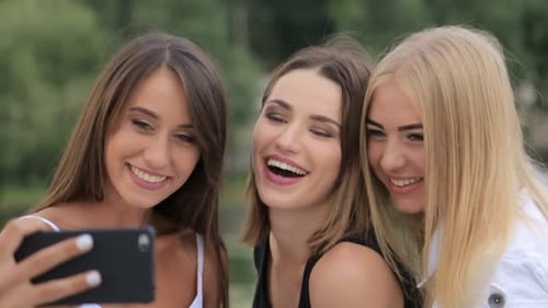 Three Cheerful Women Taking Selfie Outdoors Together
