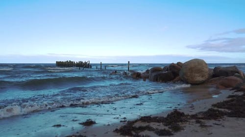 Remains of an Old Pier on Seaport. Rocks and Logs.
