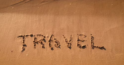 Travel Written in Sand on a Sunny Beach