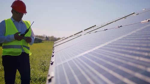 Ingenieur, der arbeitet, nutzt Tablet in der Nähe von Solarbatterien, Bau, erneuerbare Energie, Arbeiter, Technologie