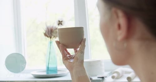 Woman Holding a Handmade Pottery Cup in Studio