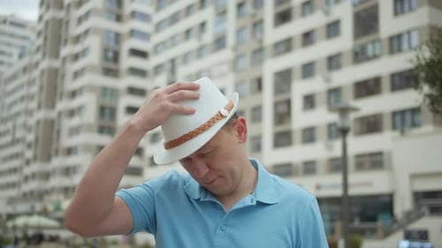 Portrait of Attractive Man in Hat on Background of City Buildings Camera Tracking