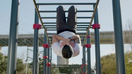 Muscular Man Hanging on Monkey Bar and Doing Abs