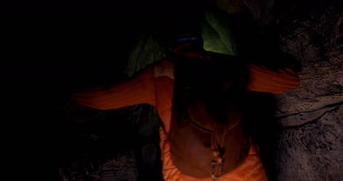 Alpinista masculino explorando uma caverna escura 4k