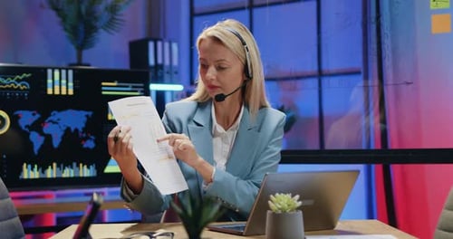 Empresaria con auriculares inalámbricos sentada frente a una computadora portátil durante una videoconferencia