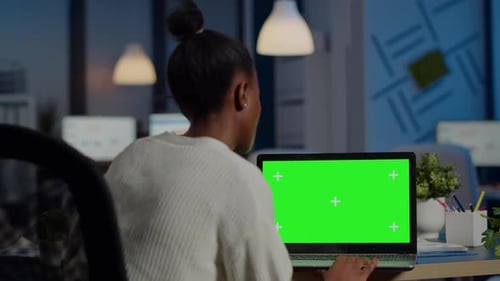 Woman Typing on Green Screen Laptop in Office