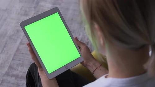 Woman With A Tablet Pc In Hands With A Green Screen, Chroma Key.