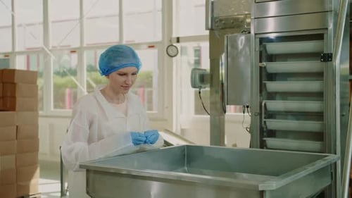 Fabrikarbeiter überprüft Verpackungsmaschine. Süßwarenfabrik.