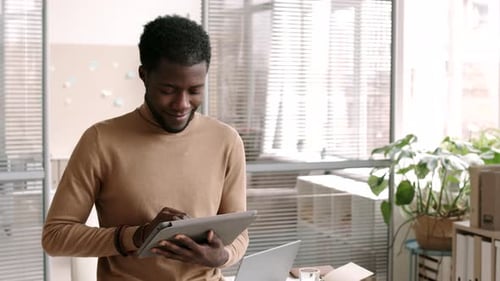 Young Adult Using Tablet in Modern Workplace