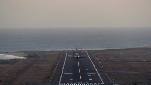 Airplane Takes Off Near Ocean at Sunrise