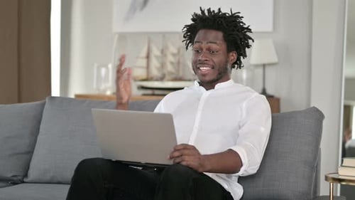 Man Video Calling On Laptop While Sitting On Couch