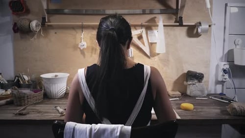 Woman works in pottery workshop