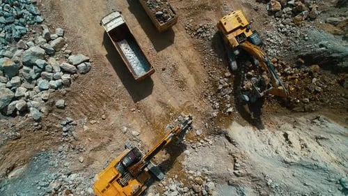 Excavators Load Trucks in Rock Quarry Aerial