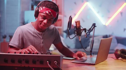 Positive Black Sound Producer Posing for Camera in Home Recording Studio