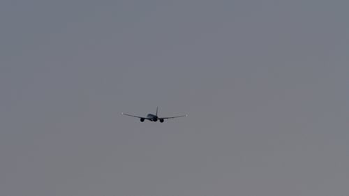 Flugzeug fliegt in mattem grauen Himmel