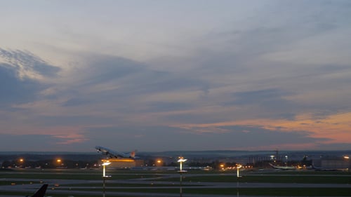 Airplane Takes Off at Dusk From Airport Runway