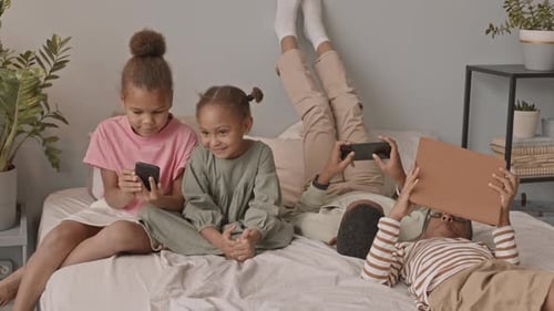 Children Using Technology Devices Together Indoors